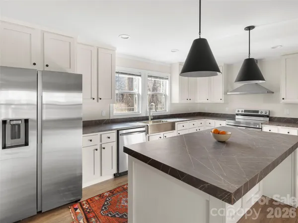 a kitchen with stainless steel appliances granite countertop a sink a stove and a refrigerator