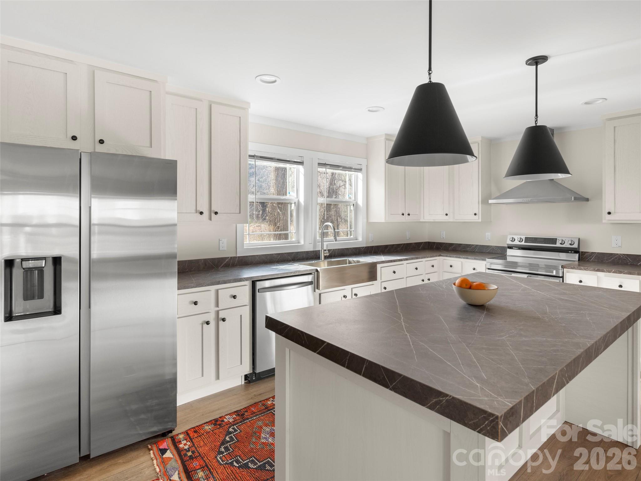 a kitchen with stainless steel appliances granite countertop a sink a stove and a refrigerator