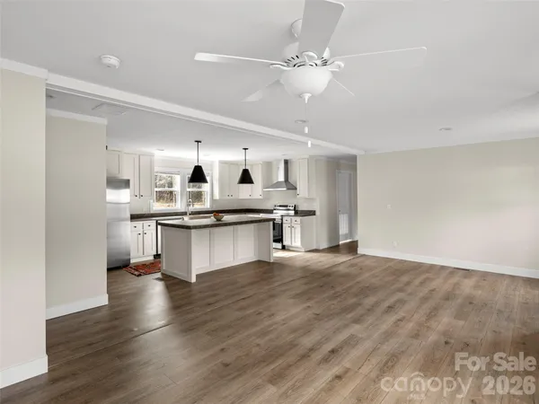 a large kitchen with cabinets wooden floor and stainless steel appliances