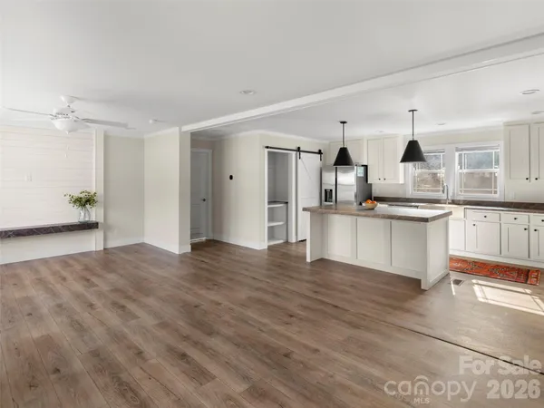 a view of a kitchen with wooden floor and electronic appliances