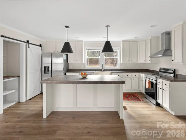 a kitchen with stainless steel appliances granite countertop a sink a stove and refrigerator