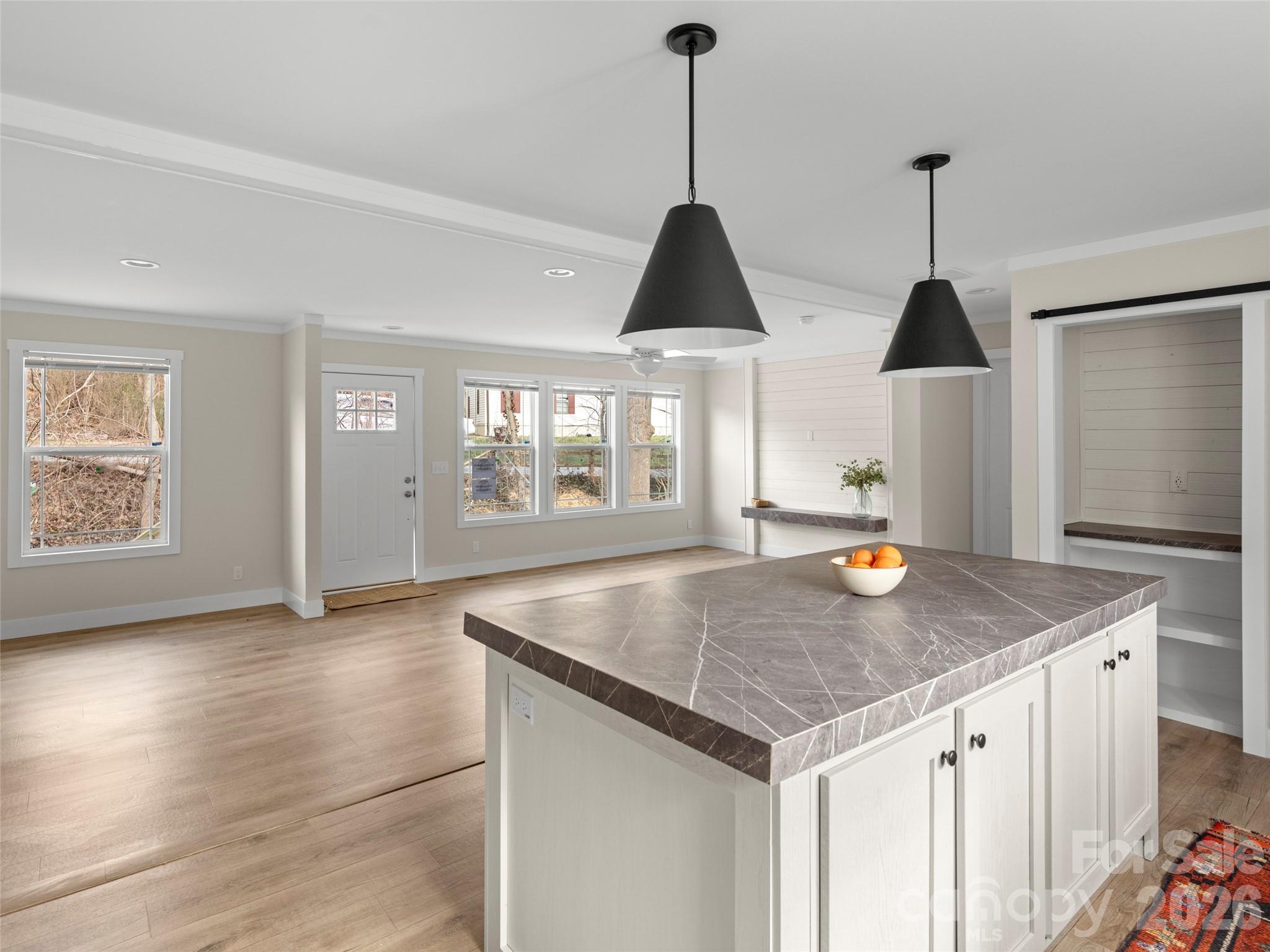2095 Emmas Grove Road Fairview, NC 28730 - Photo 10 of 24 a view of a kitchen island a sink wooden floor dining and living room view