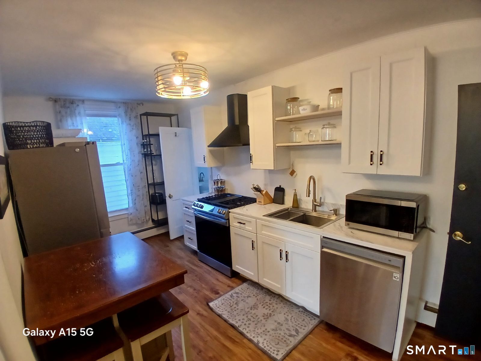 117 Water Street Stonington, CT 06378 - Photo 16 of 40 a kitchen with stainless steel appliances granite countertop a sink stove and refrigerator