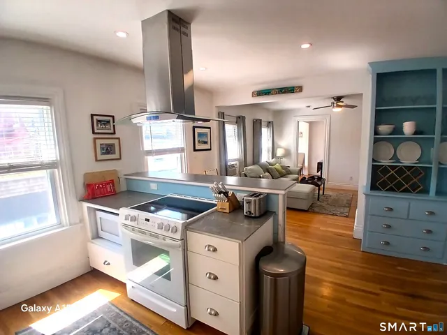 a kitchen with stainless steel appliances kitchen island granite countertop a stove a sink and a refrigerator