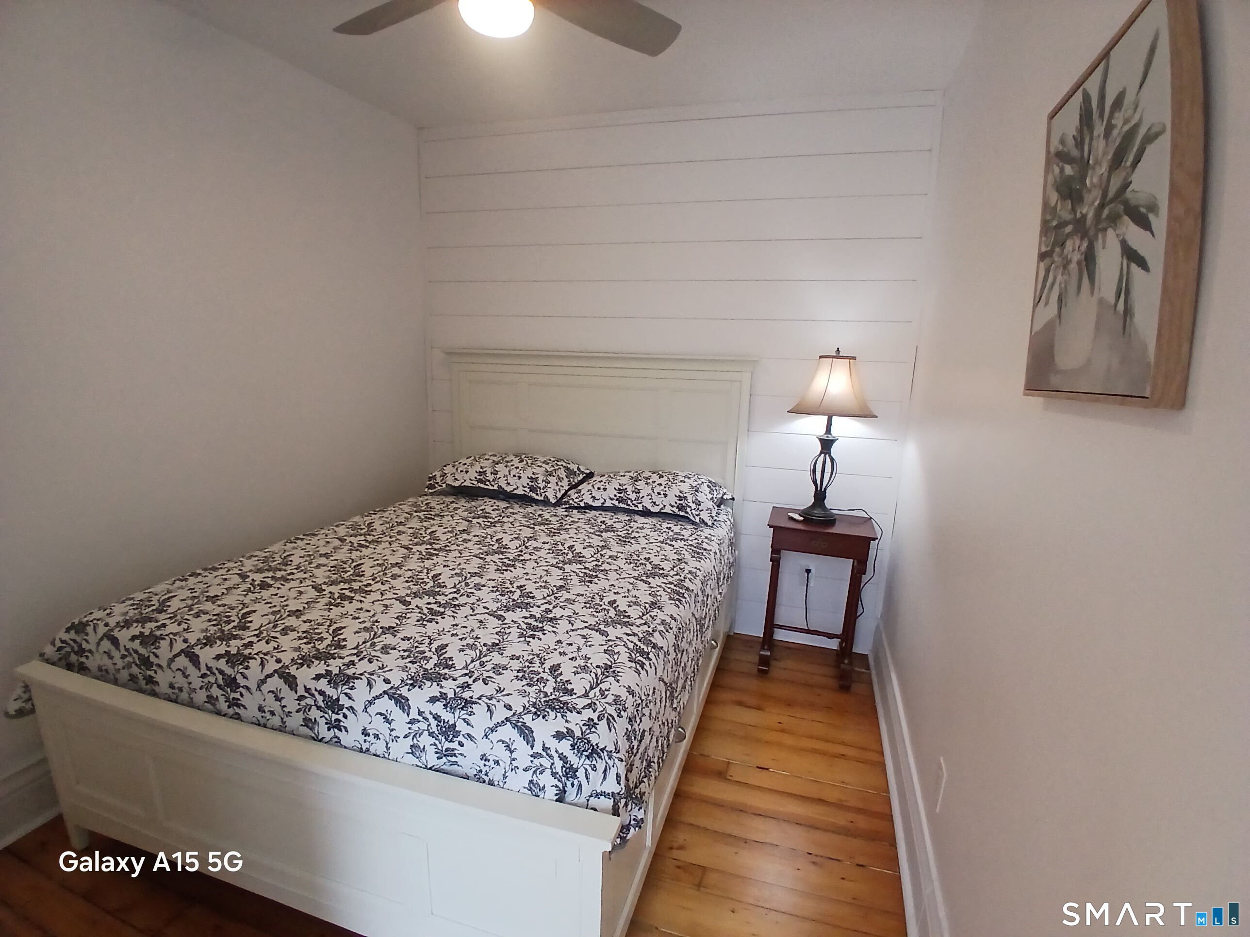 117 Water Street Stonington, CT 06378 - Photo 24 of 40 a bed sitting in a bedroom next to a lamp