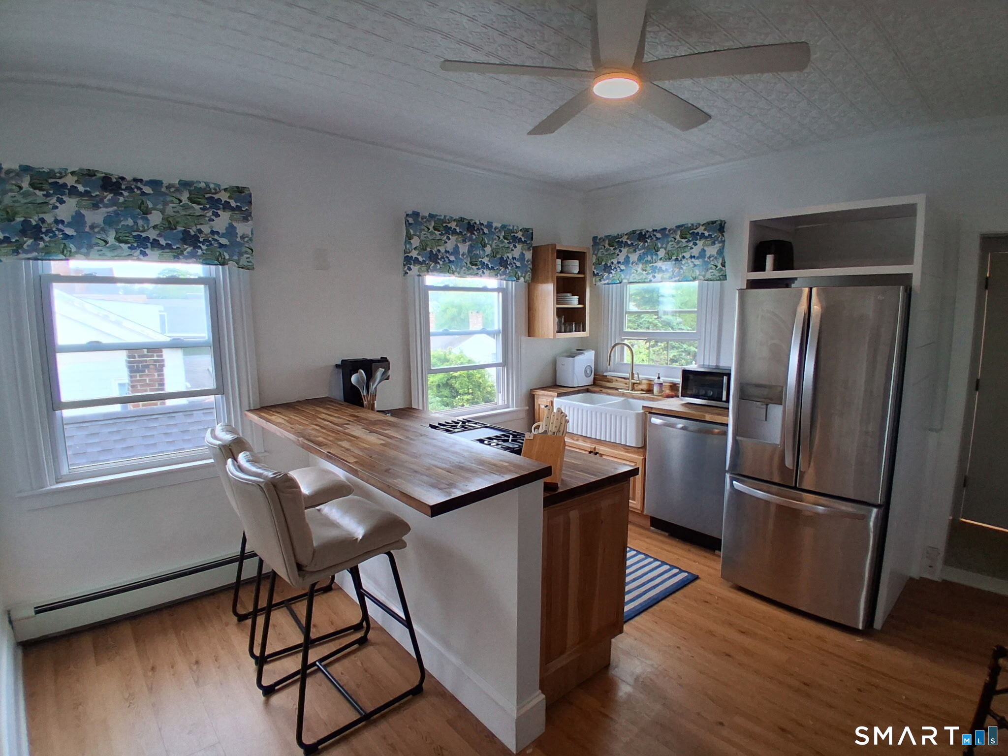 117 Water Street Stonington, CT 06378 - Photo 31 of 40 a kitchen with stainless steel appliances granite countertop a refrigerator a sink dishwasher a stove and a refrigerator with wooden floor