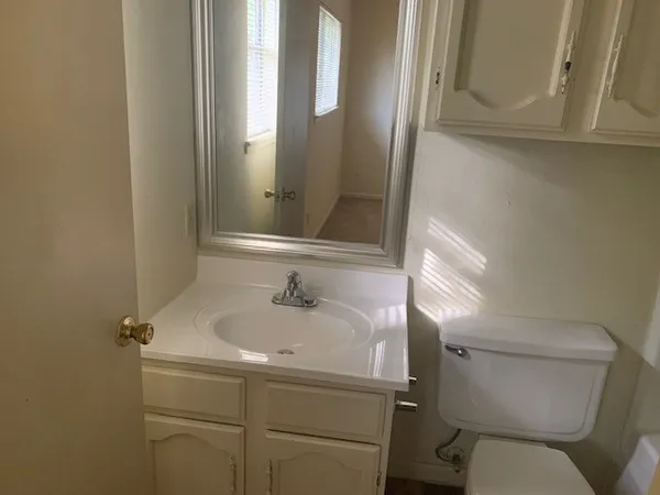 a bathroom with a sink and mirror with toilet