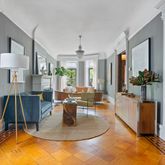 a living room with furniture a chandelier and a dining table