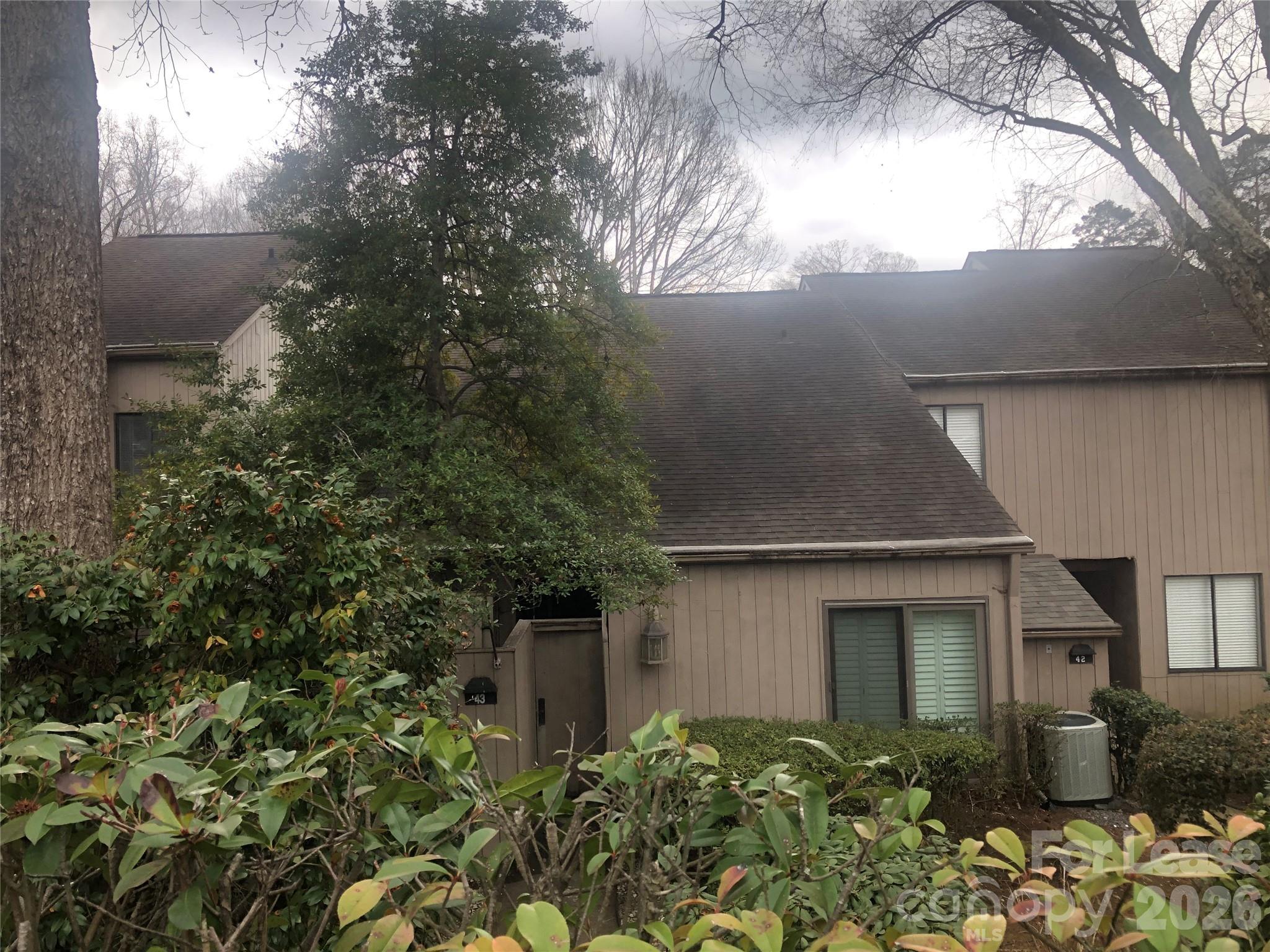 a front view of a house with plants and trees