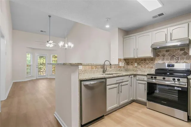 a kitchen with a sink stove and cabinets