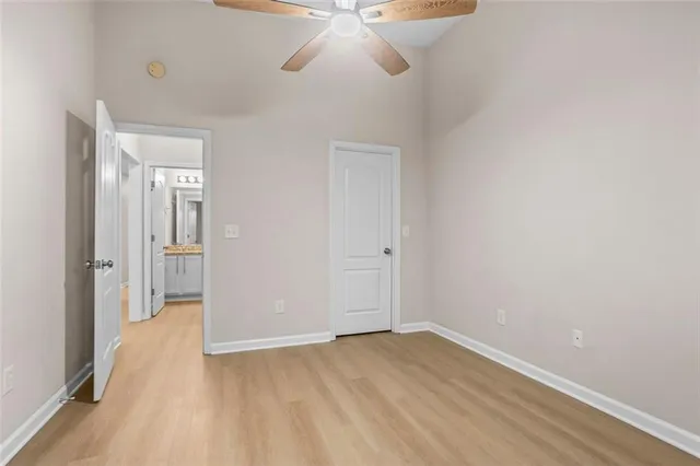 a view of a room with wooden floor and a ceiling fan