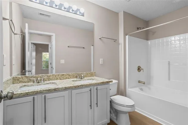 a bathroom with a granite countertop sink toilet and shower