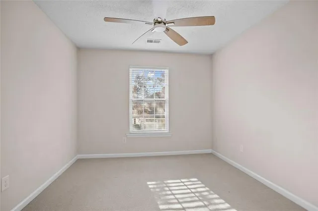 an empty room with a window and a fan
