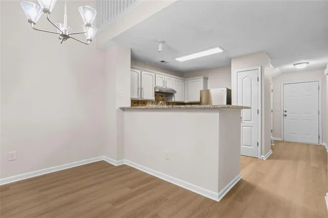 a kitchen with kitchen island white cabinets and refrigerator