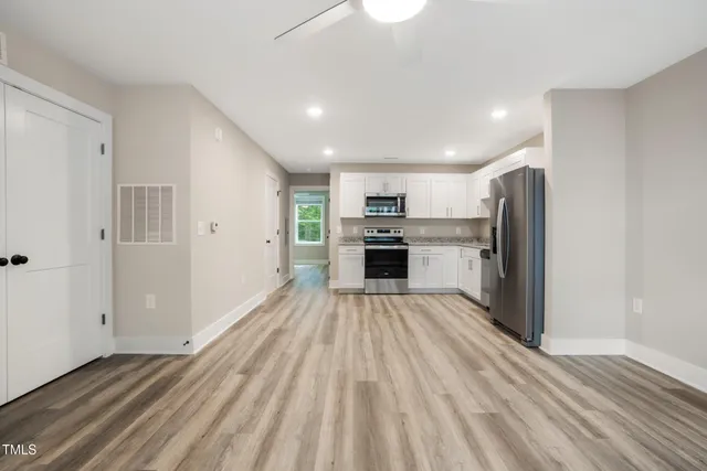 a view of kitchen with refrigerator microwave and stove top oven