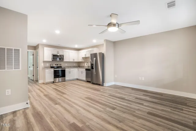 a view of kitchen with wooden floor electronic appliances and window