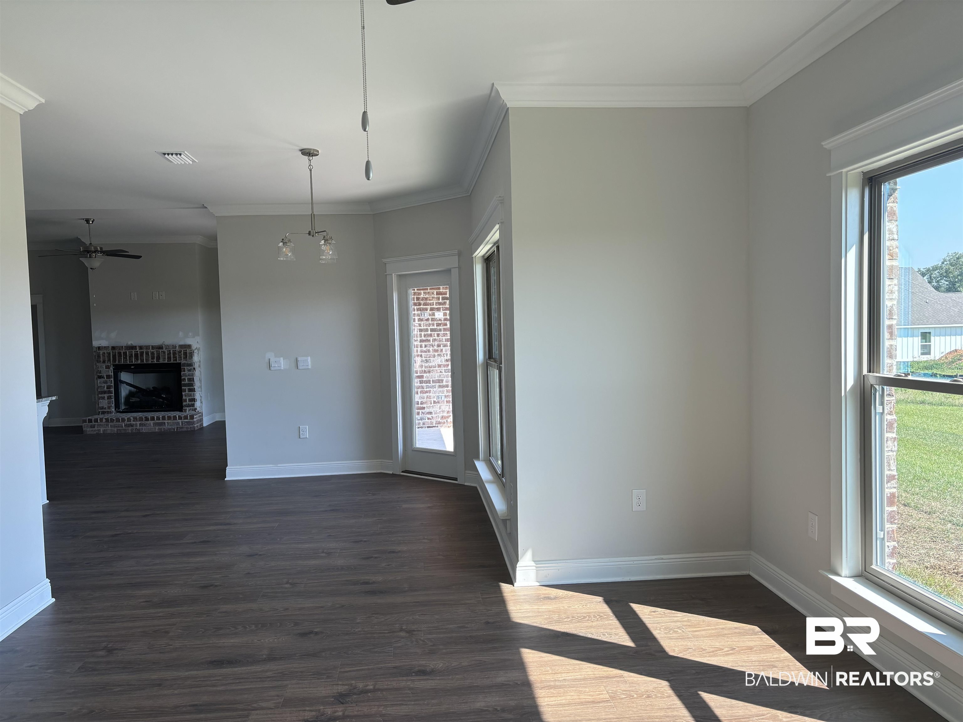 388 Garrison Boulevard Fairhope, AL 36532 - Photo 14 of 34 Unfurnished room with a fireplace, crown molding, and dark hardwood / wood-style flooring