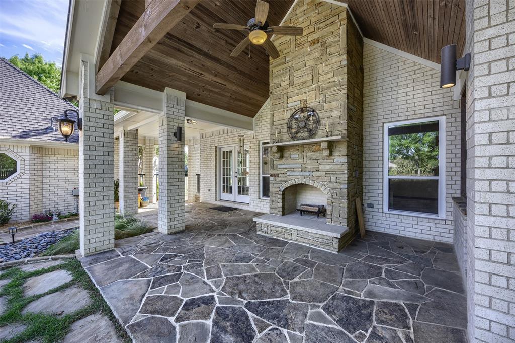 7225 Moss Ridge Road Parker, TX 75098 - Photo 21 of 40 Expansive outdoor patio featuring flagstone paving, a stone fireplace, brick walls, and a wood plank ceiling with a ceiling fan