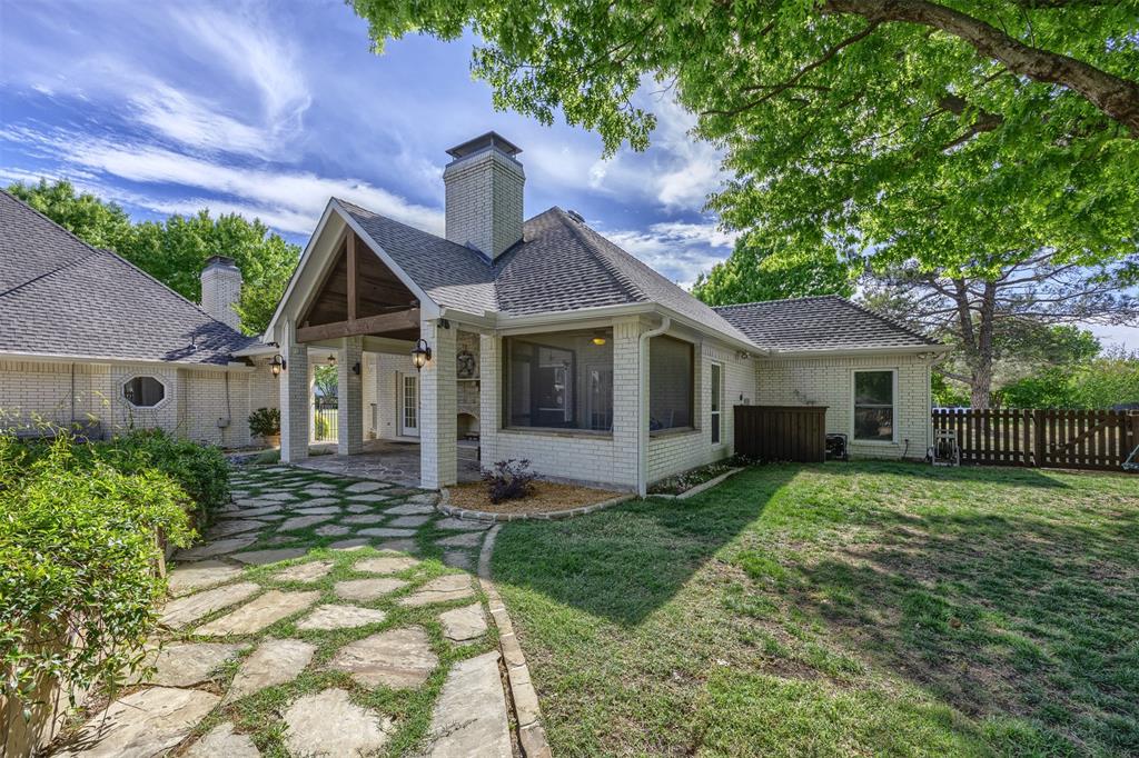 7225 Moss Ridge Road Parker, TX 75098 - Photo 26 of 40 The property features a stone paver pathway leading to a covered, screened in patio with vaulted wood beam ceilings