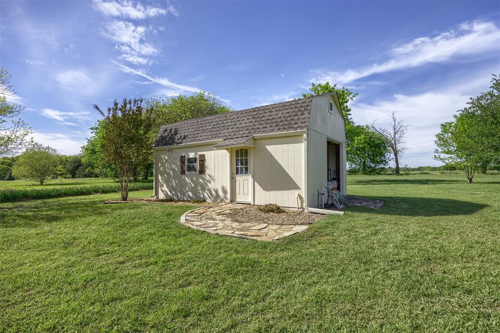 7225 Moss Ridge Road Parker, TX 75098 - Photo 29 of 40 The property features a detached shed with a gabled roof and a side access door
