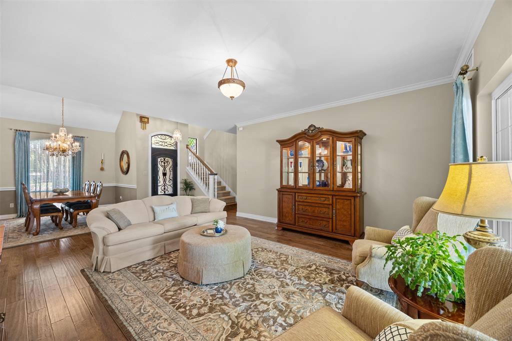 7225 Moss Ridge Road Parker, TX 75098 - Photo 3 of 40 The living area features hardwood floors, a decorative area rug, and crown molding