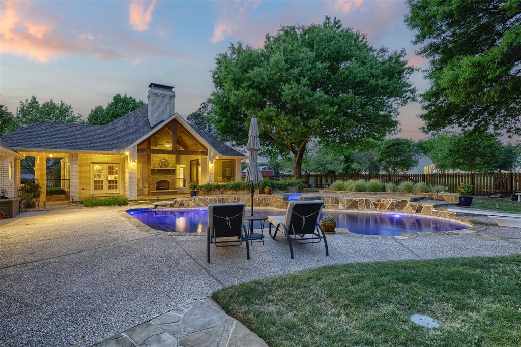 7225 Moss Ridge Road Parker, TX 75098 - Photo 36 of 40 The property features a swimming pool with rock detailing, a spacious patio area, and a brick exterior