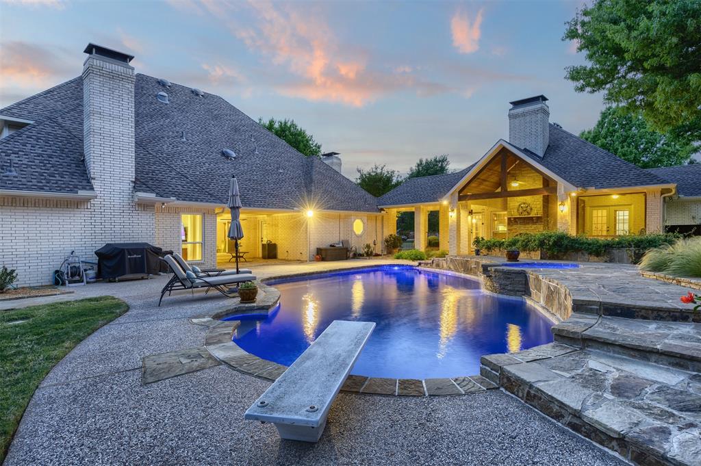 7225 Moss Ridge Road Parker, TX 75098 - Photo 38 of 40 The property features a large, irregularly shaped swimming pool with a diving board, surrounded by a stone patio and a manicured lawn
