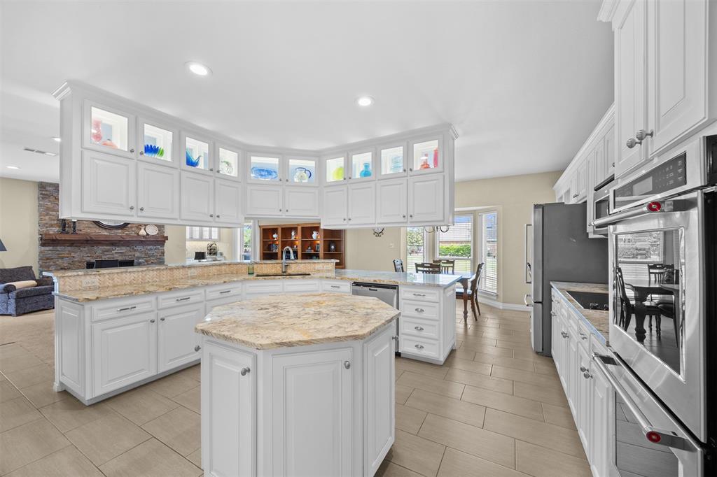 7225 Moss Ridge Road Parker, TX 75098 - Photo 5 of 40 Expansive kitchen featuring white cabinetry, light-colored countertops, and integrated stainless steel appliances