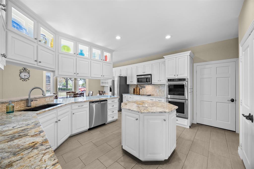 7225 Moss Ridge Road Parker, TX 75098 - Photo 6 of 40 Well-appointed kitchen featuring white cabinetry, granite countertops, stainless steel appliances, and a central island
