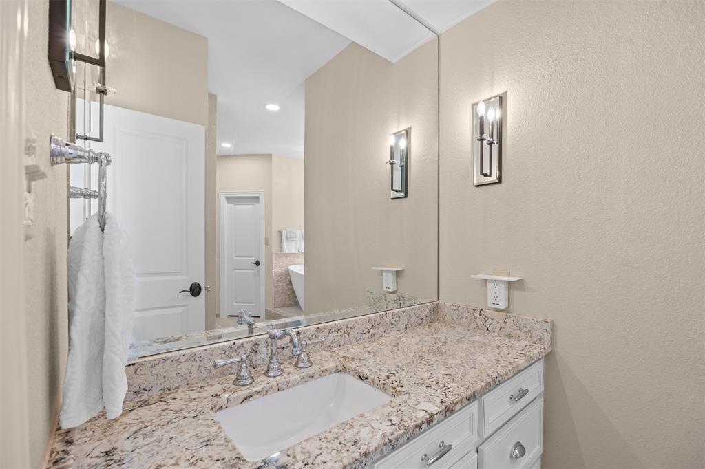 7225 Moss Ridge Road Parker, TX 75098 - Photo 10 of 40 Bathroom vanity featuring a granite countertop, a single sink with a chrome faucet, and white cabinetry with chrome hardware