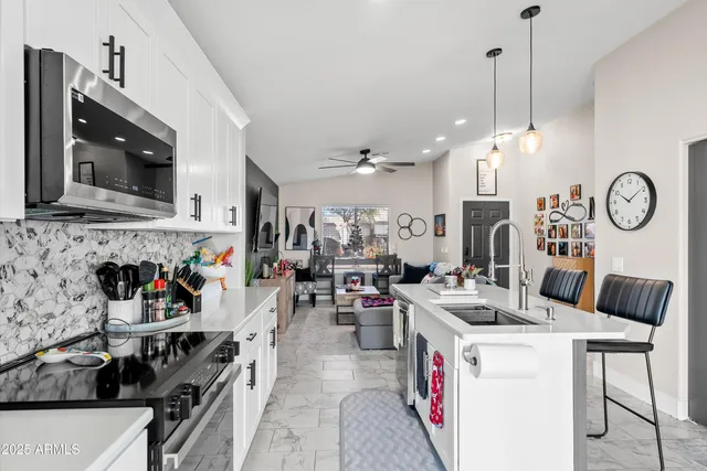 a kitchen with a sink a stove and chairs