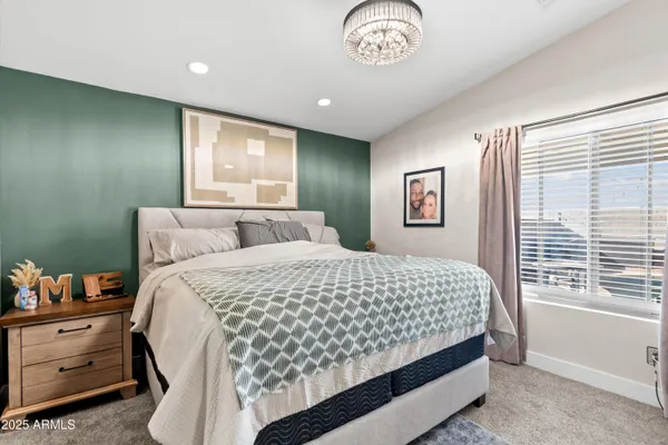 a bedroom with a large bed and a chandelier