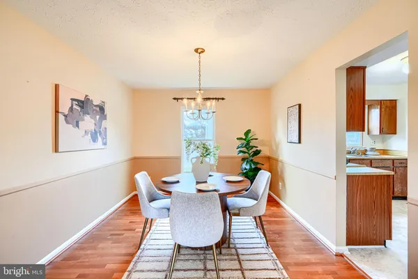 a dining room with furniture a chandelier and wooden floor