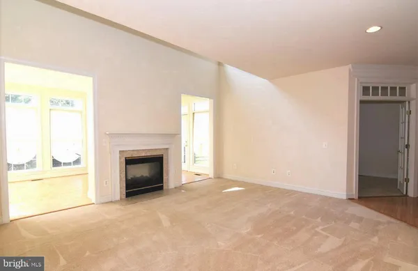 a view of empty room with a fireplace and a window