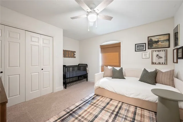 a bedroom with a bed cabinets and a window