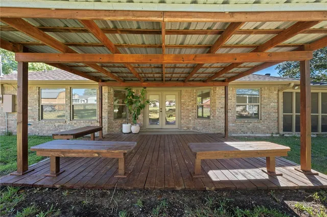 a view of a backyard with table and chairs with wooden floor and fence