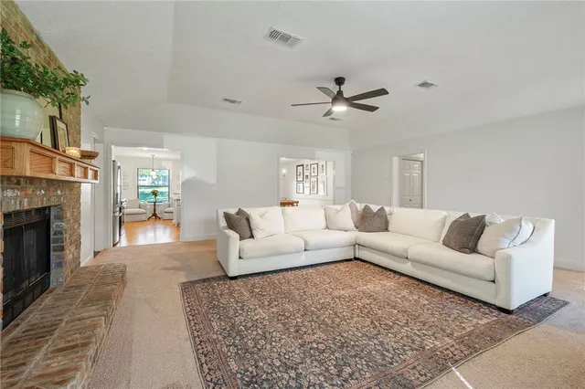a living room with furniture a fireplace and a chandelier