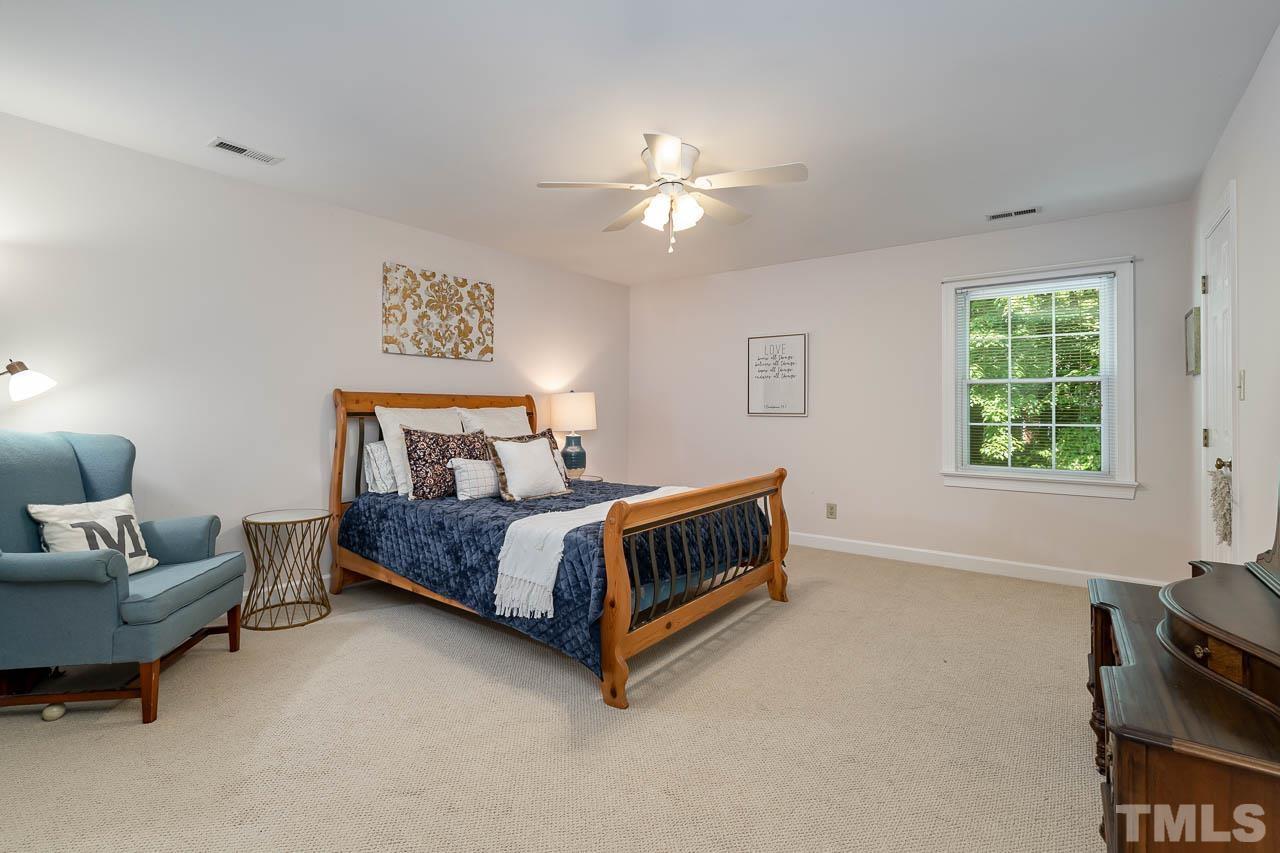 738 Weathergreen Drive Raleigh, NC 27615 - Photo 21 of 31 a bedroom with a bed and a chandelier