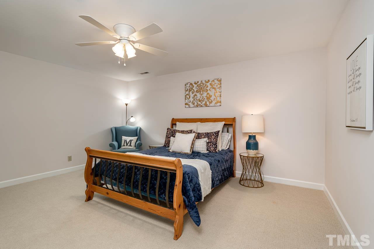 738 Weathergreen Drive Raleigh, NC 27615 - Photo 22 of 31 a bedroom with a bed and a chandelier