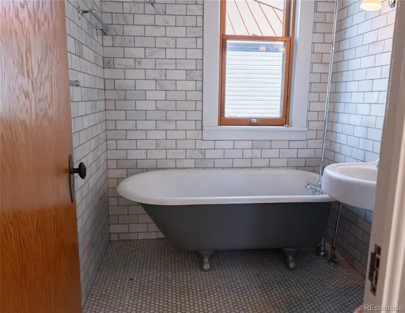 a bathroom with a bathtub and next to a window