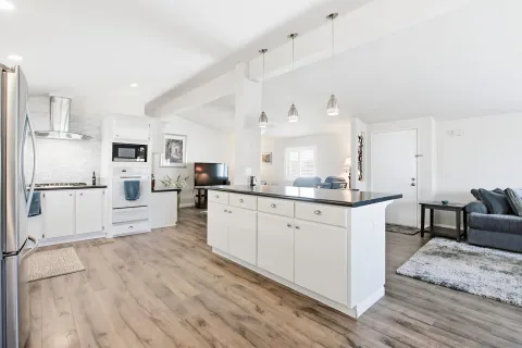 a kitchen with white cabinets and stainless steel appliances