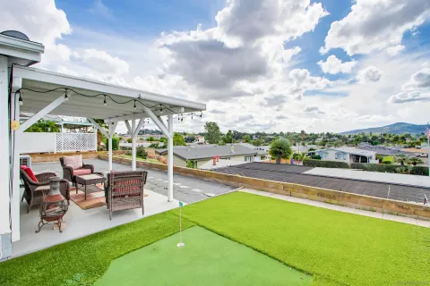 a view of a patio with table and chairs with wooden floor and fence