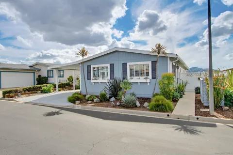a view of a house with a cars park side of a road