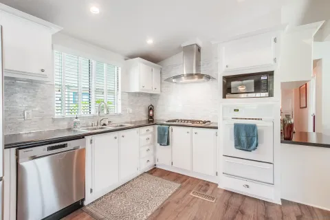 a kitchen with white cabinets and white appliances