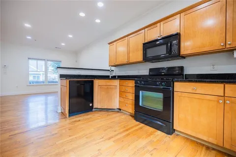 a kitchen with stainless steel appliances granite countertop a stove top oven a sink and a microwave