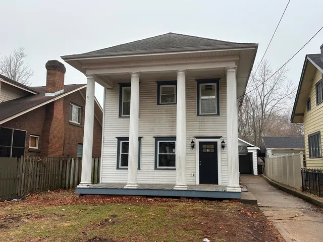 a view of a house with a small yard and wooden floor and fence
