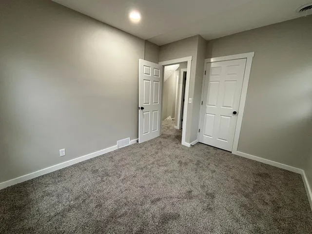 an empty room with closet and mirror
