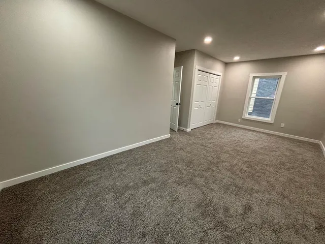an empty room with windows and closet