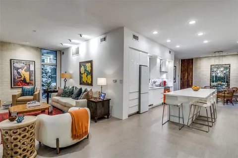 a living room with furniture and a dining table with kitchen view