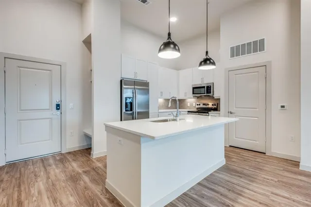 a kitchen with kitchen island white cabinets and stainless steel appliances